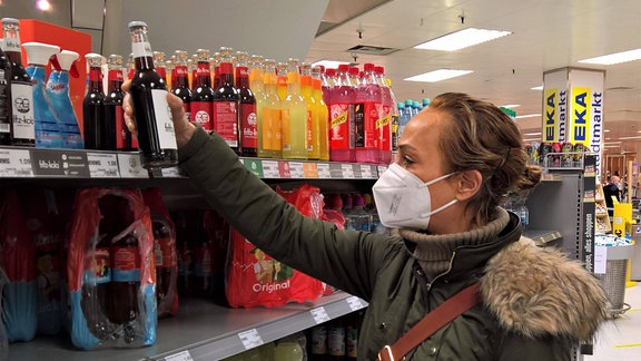 Eine Frau mit FFP2-Maske kauft im Supermarkt ein.