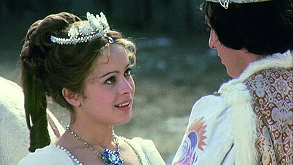 Filmszene: Aschenbrödel im Hochzeitskleid lächelt ihren Prinz an