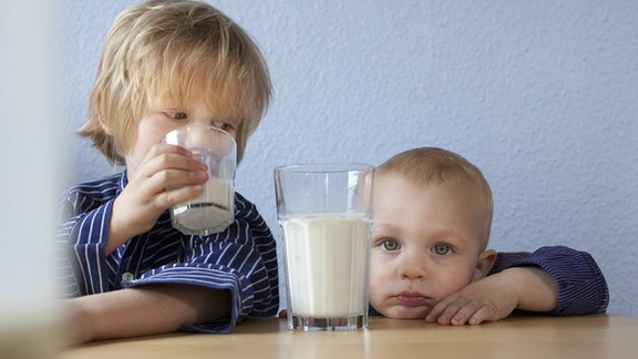 Zwei Kinder mit Milchgläsern