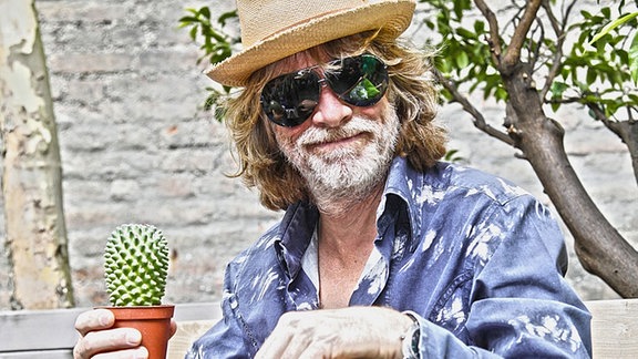 Helge Schneider mit Gitarre und Kaktus 