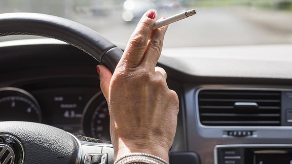 Frau raucht beim Autofahren