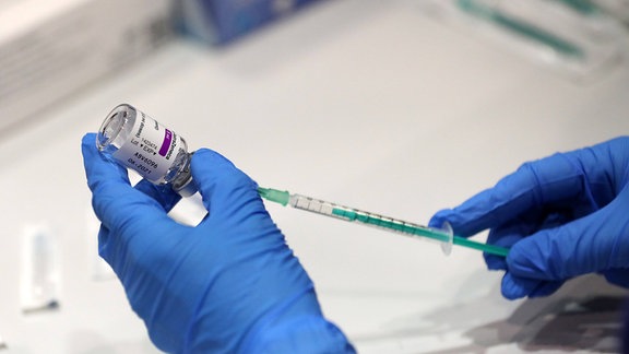 Eine Spritze wird mit dem Impfstoff AstraZeneca aufgezogen