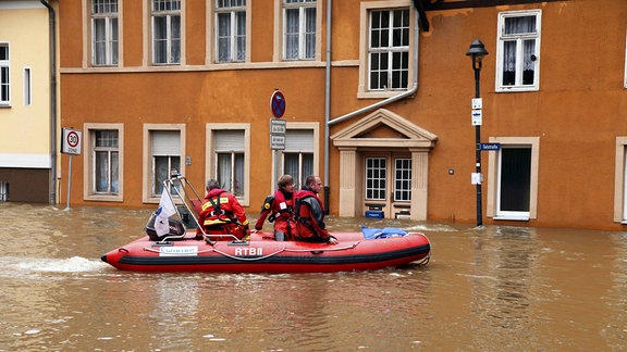 Hochwasser 2013 in Halle (Saale), Helfer fahren auf Bott durch die Straße