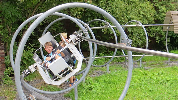 Ein Kind sitzt in einem Modell: in der Ausstellung Imaginata in Jena kann man zum Beispiel Physik mit allen Sinnen erfahren