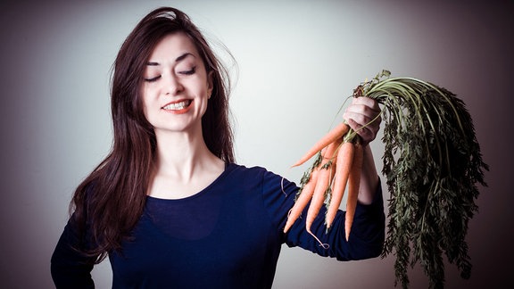 Junge Frau mit Karotten in der Hand