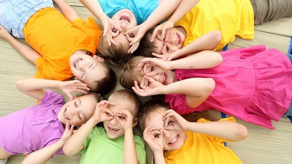 Sieben Kinder in bunten T-Shirts