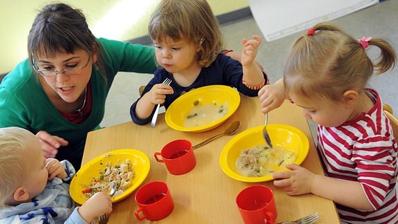 Kinder beim essen in einer Kita.