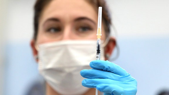 Krankenschwester hält Spritze mit Corona-Impfung