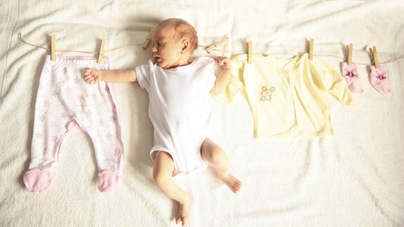 Schlafendes Baby und Kinderkleidung