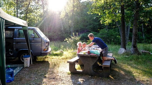 Vater mit Kindern beim sommerlichen Camping in Harriman, USA