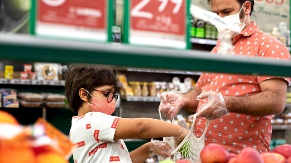 Vater und Kind mit Mund-Nasen-Schutz beim Einkaufen (Symbolfoto)